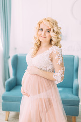 Pregnant young girl in a light orange dress