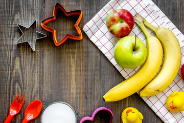 Preparing quick lunch for schoolchild. Fruits on dark wooden table background top view copyspace