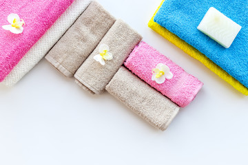 Preparing to take bath. Towels and soap on white background top view copyspace