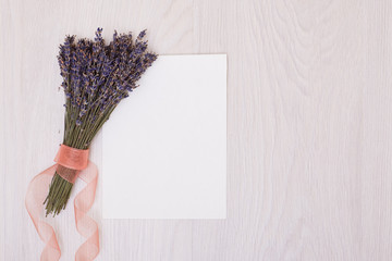 Lavender desk design with flowers on white background top view mock up. White paper postcard