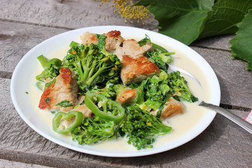 Nutritious dish of roasted pork fillet, green pepper, greens, broccoli in cream