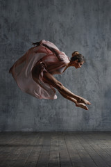 Young beautiful dancer is posing in studio