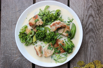 Nutritious dish of roasted pork fillet, green pepper, greens, broccoli in cream