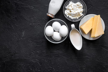 Natural food. Milk, cottage, cheese, eggs on black stone background top view copyspace