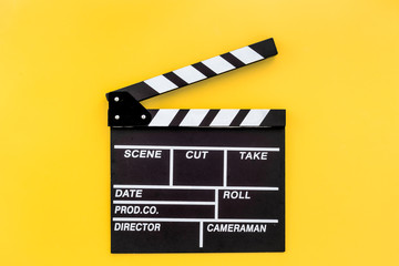 Fototapeta na wymiar Filmmaker profession. Clapperboard on yellow background top view copyspace