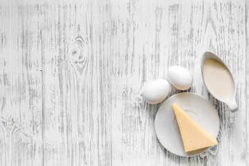 Natural food. Milk, eggs, cheese on light wooden background top view copyspace