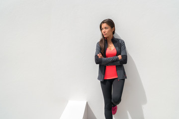 Activewear Asian girl model woman leaning on wall in yoga leggings and running jacket ready to...