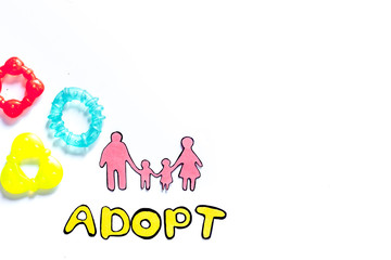 Adopt word, paper silhouette of family and toys on white background top view copyspace