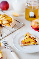 Sweets, desserts and pastries, French cuisine, biscuits, galette with peaches, fresh fruits, milk and green tea on a light background 