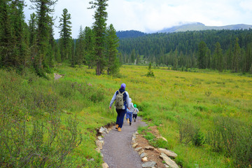 Obraz premium Hiking family in the taiga forest
