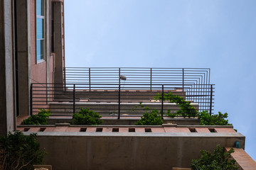 Looking up view from below of a house with balcony in loft style red bricks. Looking up to the sky
