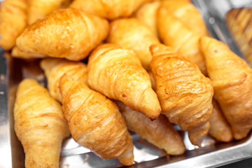 Fresh croissants in plate at supermarket store