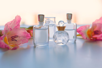 Different small bottle of perfume with pink flowers