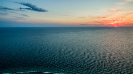 sunset from a bird's flight over a calm sea