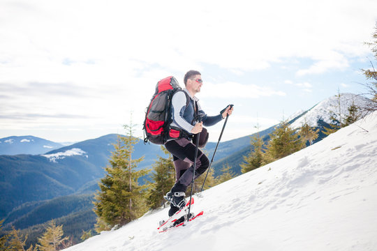 Male tourist in snow snowshoes.