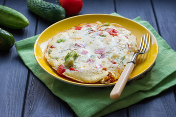 omelette from chicken eggs with cheese, fresh vegetables - cucumber and tomato