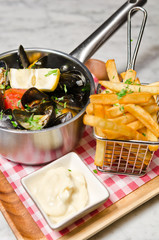 Pan cooked garlic mussels in a white wine sauce served with french fries, lemon wedge and white sauce.