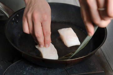 Pan fried golden fish fillet cubes, frying in real butter, in a non stick rustic pan.
