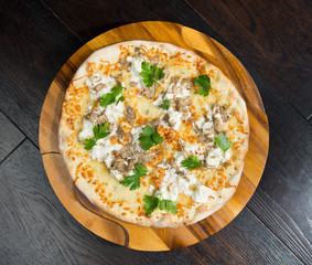 Gourmet goats cheese, mozzarella and truffle pizza served on a rustic wooden board