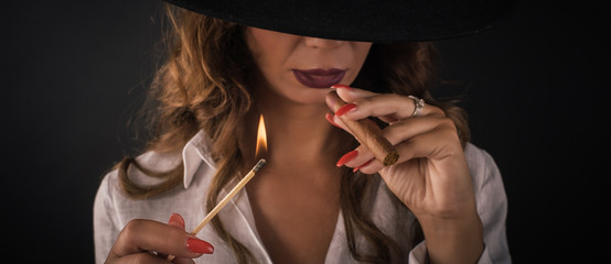 Portrait of sexy elegant lady woman with hat smoking cigar