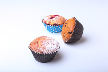 Homemade Blueberry and chocolate muffins with powdered sugar and fresh berries.