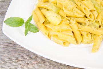 Penne with pesto and zucchini decorated with mint