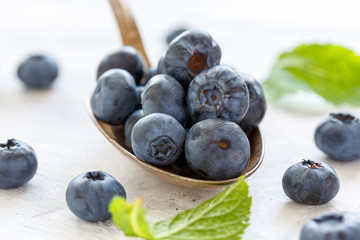 Ripe blueberries in a tablespoon of closeup.