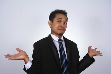 Photo image of a handsome attractive young Asian businessman with i don't know gesture isolated on white