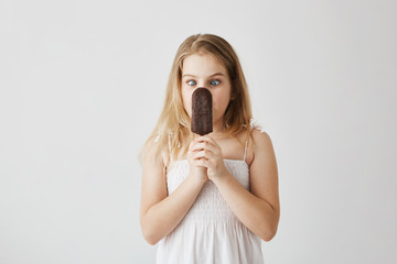 A studio portrait of a little girl enjoying her ice-cream and having fun