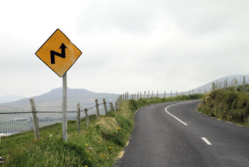 Yellow sign with winding road symbol