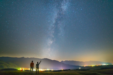 The two friends stand gesture on the background of the stars. night time