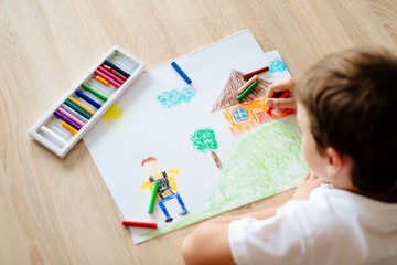 Child drawing picture of boy going to school.