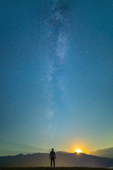 Obraz na płótnie Canvas The man stand on the background of the milky way. night time