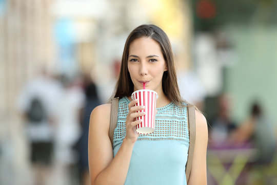 Front view of a girl sipping a takeaway drink