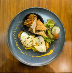 Mexican on toast sandwich with fried egg, cucumber, tomatoes, and vegetable salad