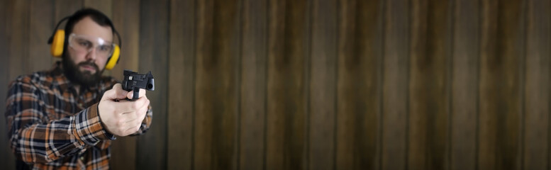 man with put on protective goggles and ear training in pistol shooting