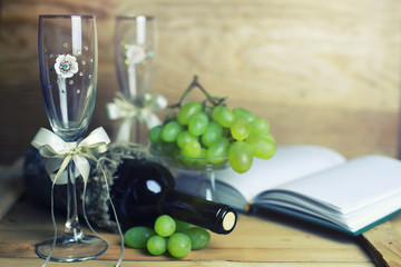 wooden table with wine bottle book and grape
