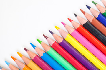 A drawing tool. Objects for creativity. Colored pencils on a light background in a diagonal line.