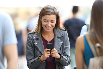 Teen chatting on smart phone surrounding by people