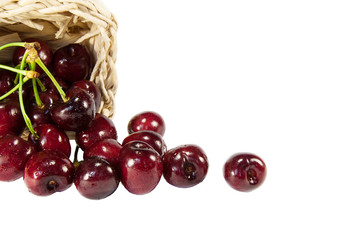 cherries in a wicker basket isolated on white background