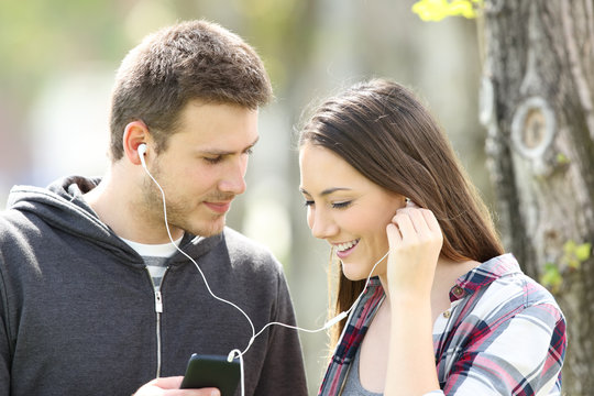Couple flirting and sharing music outdoors