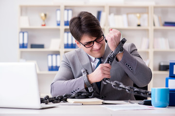 Businessman tied with chains to his work