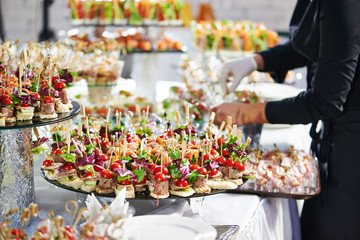 Waiter serving catering table in restaurant