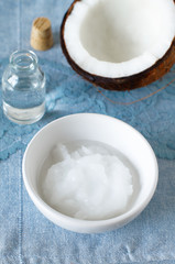 Coconuts and organic coconut oil in a glass jar on white background. Alternative therapy and super food.