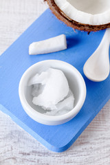 Coconuts and organic coconut oil in a glass jar on white background. Alternative therapy and super food.