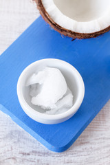 Coconuts and organic coconut oil in a glass jar on white background. Alternative therapy and super food.