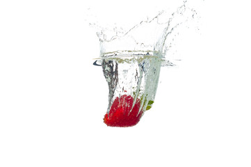Strawberry falling in the water with splash, isolated on a white background