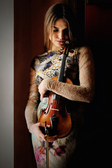 Young violinist girl with light from the window
