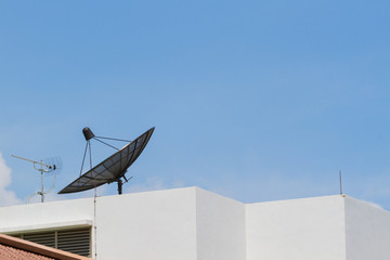 Antenna and satellite dish on the top of the building in the sky background, Thailand, Horizontal photo.