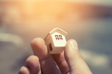 Toy house in hand. The concept of the mortgage

